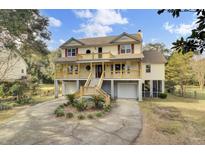 Two-story house with double garage, large porch, and landscaped yard at 1661 Battalion Dr, Charleston, SC 29412