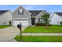 Suburban home with 2-car garage, manicured lawn, and neutral siding at 207 Loocock Dr, Goose Creek, SC 29445