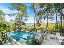 Inviting pool with wooden deck overlooking tranquil water views at 26 Cormorant Island Ln, Kiawah Island, SC 29455