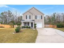 Two-story house with gray siding, attached garage, and landscaped yard at 3043 Mapleleaf Dr., Moncks Corner, SC 29461