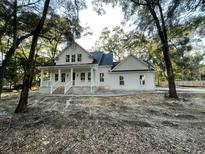 White farmhouse exterior with wraparound porch and mature trees at 3315 Hopkinson Plantation Rd, Johns Island, SC 29455