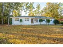 White brick ranch house with landscaped yard and mature trees at 411 Constance St, Walterboro, SC 29488
