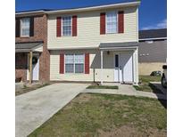 Brick and vinyl siding townhouse with red shutters and a concrete driveway at 6884 Shahid Row, North Charleston, SC 29418