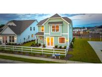 Two-story light green house with white trim, and a white picket fence at 729 Opal Wing St, Moncks Corner, SC 29461