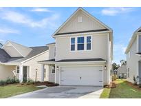 Two-story house with beige siding, white garage door, and landscaping at 733 Opal Wing St, Moncks Corner, SC 29461