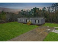 Single-wide manufactured home on a spacious lot with a wooden deck at 857 Devines Way, Cross, SC 29436