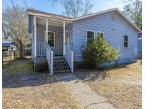 Cute blue house with a porch and steps leading to the front door at 2749 E Surrey Dr, North Charleston, SC 29405