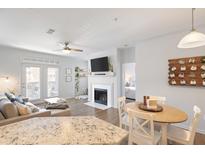 Bright living room with fireplace, hardwood floors, and access to a balcony at 45 Sycamore Ave # 625, Charleston, SC 29407