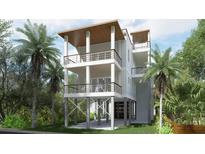 Elevated home with light blue siding, multiple balconies, and tropical landscaping at 615 W Beach Ct, Folly Beach, SC 29439