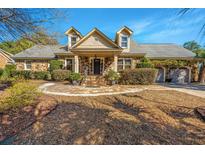 Charming stone & shingle home with landscaped yard, two-car garage, and inviting front porch at 19 Charing Cross Rd, Charleston, SC 29407