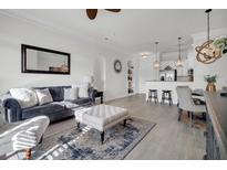 Bright living room with comfy seating, large mirror, and stylish ottoman at 200 River Landing Dr # 107H, Daniel Island, SC 29492