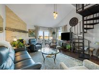 Spacious living room with fireplace, spiral staircase, and access to deck at 2335 Tall Sail Dr # 508H, Charleston, SC 29414