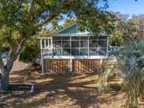 Charming beach cottage with a screened porch and large oak tree at 2407 Myrtle St, Edisto Beach, SC 29438