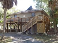 Elevated beach cottage with wrap-around deck and stairs at 506 Jungle Rd, Edisto Island, SC 29438