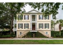 Grand three-story home with black shutters, a classic design, and a lush green landscape at 75 Hopetown Rd, Mount Pleasant, SC 29464