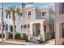 Charming two-story home with gray facade, white trim, and landscaping at 99 Tradd St, Charleston, SC 29401