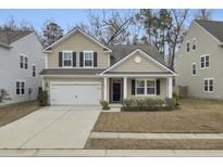 Two-story house with beige siding, black shutters, and a white garage door at 9991 Winged Elm St, Ladson, SC 29456