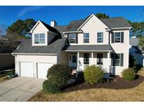 Two-story house with a beige exterior, two-car garage, and landscaping at 109 Historic Dr, Mount Pleasant, SC 29464