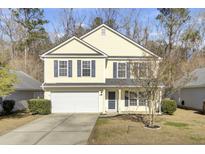 Two-story yellow house with a white garage door and dark shutters at 114 Avalon Rd, Summerville, SC 29483
