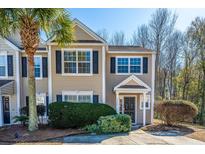 Tan two-story house with dark shutters, landscaping, and a driveway at 1295 Island Club Dr # E, Charleston, SC 29492