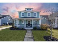 Two-story light teal house with white porch and landscaping at 176 Callibluff Dr, Summerville, SC 29486