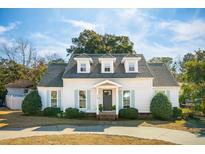 Charming white house with gray roof, landscaping, and a circular driveway at 947 Night Heron Dr, Mount Pleasant, SC 29464