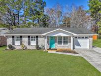 Charming one-story brick home with a teal door, attached garage, and well-manicured lawn at 1022 Margaret Dr, Ladson, SC 29456