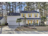 Two-story white house with yellow shutters, landscaping, and a driveway at 125 Trickle Dr, Summerville, SC 29483