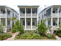 Charming white two-story home featuring a screened porch and landscaped front yard at 1474 Mizzen Aly, Johns Island, SC 29455