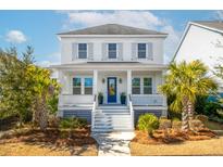 Two-story white house with blue door, front porch, and palm trees at 2451 Louisville St, Charleston, SC 29492