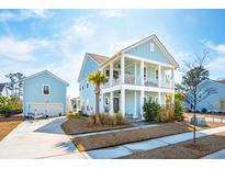 Two-story light blue house with white trim, balcony, detached garage, and landscaping at 2545 Hatch Dr, Johns Island, SC 29455