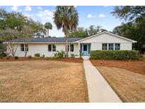 Charming white brick ranch home with a light blue door and manicured lawn at 3906 Waterway Blvd, Isle of Palms, SC 29451