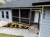 Newly painted house with screened porch, landscaping, and black fence at 402 Citadel St, Ladson, SC 29456