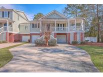 Two-story home with brick and siding, a porch, and a two-car garage at 4816 8Th Tee Dr, Hollywood, SC 29449