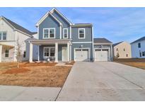 Two-story blue house with white trim, two-car garage, and landscaping at 1002 Field Sparrow Dr # Cc3-24-1, Ravenel, SC 29470
