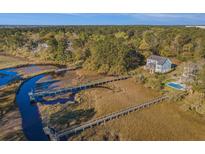 Aerial view of waterfront home with private docks and a pool; surrounded by lush greenery at 1034 Bradbury Ln, Charleston, SC 29492