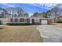 Brick ranch home with attached garage and landscaped yard at 1264 Fort Dr, Hanahan, SC 29410