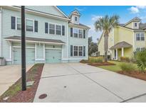 Front view of two-story townhouses with attached garages and landscaped yards at 1455 Red Tide Rd, Mount Pleasant, SC 29466