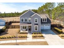 Charming two-story home with a covered porch and swing, complemented by a well-manicured lawn at 200 Clearblue Loop, Summerville, SC 29486