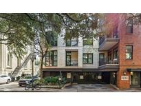 Brick building exterior with gated parking and tree-lined street at 21 George St # 114, Charleston, SC 29401