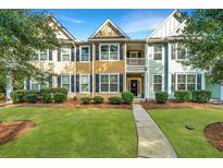 Tan and teal townhouses with black shutters, landscaping, and a walkway at 2136 Promenade Ct, Mount Pleasant, SC 29466