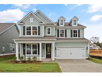 Two-story house with light green siding, white garage door, and landscaped lawn at 738 Maynard Ln, Summerville, SC 29486