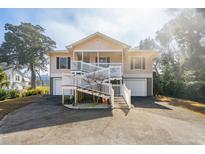 Two-story beach home with elevated deck, double garage, and spacious driveway at 804 E Ashley Ave, Folly Beach, SC 29439