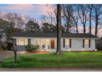 Charming ranch home with gray and white exterior, well-manicured lawn, and mature trees at 1385 Fairfield Ave, Charleston, SC 29407