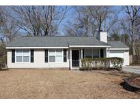 Tan vinyl-sided house with gray roof, black shutters, and small porch at 186 Bridgecreek Dr, Goose Creek, SC 29445