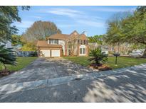 Traditional two-story home with a brick facade, two car garage, and landscaped front yard on a sunny day at 2049 Country Lake Ct, Charleston, SC 29414