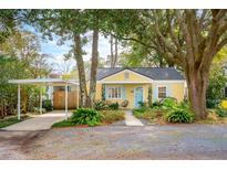 Charming yellow cottage with mature trees and a covered carport, offering curb appeal and functionality at 2149 Stonewood Dr, Charleston, SC 29412