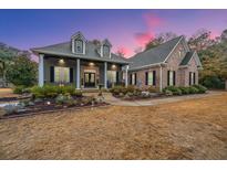 Brick and gray two-story home with landscaped yard and porch at 788 Awendaw Lakes Blvd, Awendaw, SC 29429