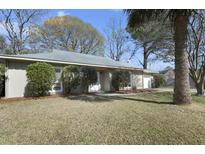 Charming single-story home with a well-maintained lawn and mature trees at 824 Farnham Rd, Charleston, SC 29412