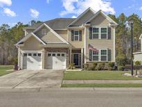 Charming two-story home with a two-car garage, landscaped yard, and neutral siding at 113 Blackwater Way, Moncks Corner, SC 29461